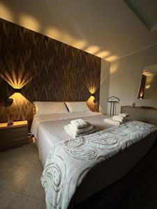 a bedroom with a large bed with white sheets at AGAS Exclusive Apartment in Catanzaro