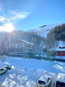 eine Gruppe von Autos, die im Schnee geparkt sind in der Unterkunft Boost Your Immo Les Deux Alpes Chalets d'or 792 in Les Deux Alpes