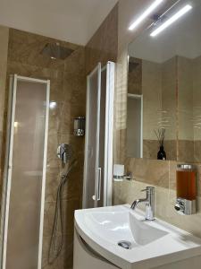 a bathroom with a sink and a shower with a mirror at AGAS Exclusive Apartment in Catanzaro