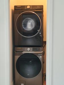 a microwave and a washing machine in a room at Chalet Listra peace & spa - 16 min to Tremblant in La Conception