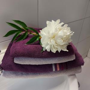 a pile of towels with a white flower on top at Feels like Home @ Eppinger in Remseck am Neckar