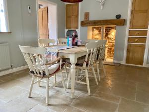 uma cozinha com uma mesa com cadeiras e uma lareira em 30 Overleigh Road em Chester