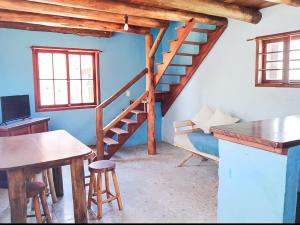 um quarto com uma escada, um sofá e uma mesa em Rosatrip Surf Bungalows em Praia do Rosa