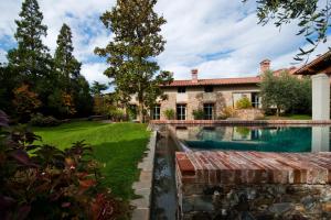 an exterior view of a house with a swimming pool at Fattoria Casamora - Villa Le Magnolie in Pian di Scò