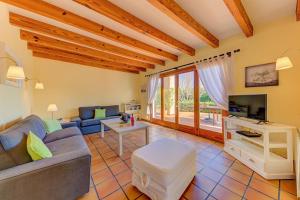 een woonkamer met een bank en een tv bij Lovely Alcudia Villa Casa De Arcos Private Pool Gardens Close to Resort Centre and Beaches in Alcudia