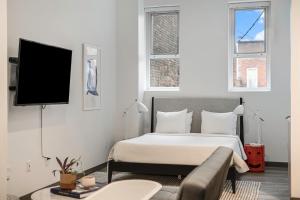 a bedroom with a bed and a flat screen tv at Exhibit A2 in Ann Arbor