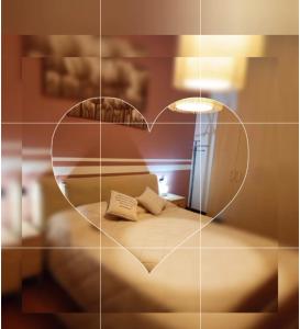a reflection of a bedroom with a heart shaped mirror at MB Place Abano Terme in Abano Terme