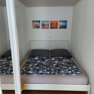 a bed in a small room with pictures on the wall at Feels like Home @ Eppinger in Remseck am Neckar