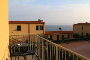 a balcony with a table and a view of the ocean at Appartamento incantevole con piscina in Cervo