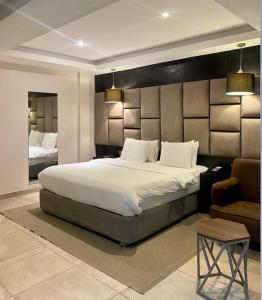 1 dormitorio con 1 cama grande y 1 silla en Joshesther Olive Hotel, en Ikeja