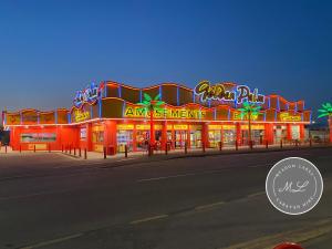 ein großes Gebäude mit Neonlichtern an einer Straße in der Unterkunft Palm Grove 183 - Golden Palm - Pet friendly, WiFi, central heating, bed linen - Meadow Lakes Caravan & Lodge Hire in Chapel Saint Leonards