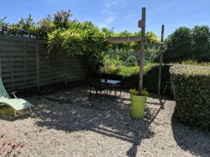 un patio con una silla, una mesa y un banco en Domaine du Martinaa, en Saint-Martin-de-la-Lieue