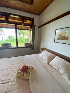 Un dormitorio con una cama blanca con una flor. en Geriasemalung en Tirtagangga