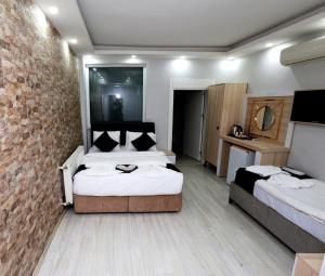 een slaapkamer met 2 bedden en een bakstenen muur bij MİLA SUİTES TAKSİM in Istanbul