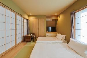 大阪市にある俪居花园酒店Reikyo Garden Hotelのベッド2台と窓が備わるホテルルームです。