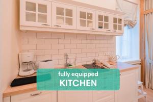 a kitchen with white cabinets and a kitchen sign that reads fully equipped kitchen at Revelton Suites Tallinn in Tallinn