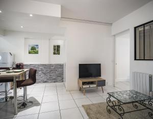 uma sala de estar com uma secretária e uma televisão em Le Colombage-3 chambres- Hypercentre em Troyes