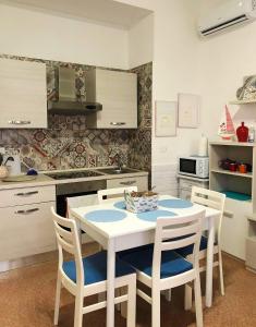 トッレ・スペッキア・ルッジェーリにあるVilla Martina fronte mare - Litoranea San Foca Torre Specchia Ruggeriのキッチン(白いテーブル、椅子付)