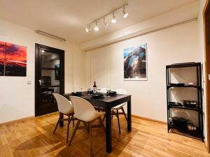 a dining room with a black table and white chairs at Apartamento Lozano in Parzán