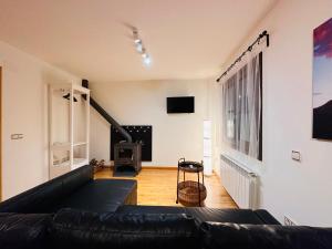 a living room with a black couch and a fireplace at Apartamento Lozano in Parzán
