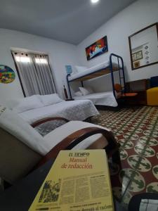 a hotel room with two beds and a sign on the floor at Hotel Posada Turística la Ceiba in Vergara