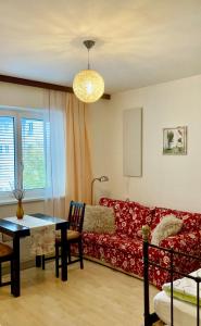 uma sala de estar com um sofá vermelho e uma mesa em Grazer Spatz em Graz