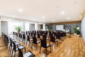 Sala de conferencias con sillas y pantalla de proyección en Reverence Mare Hotel - Adults Only en Palmanova