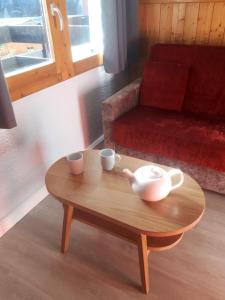 a coffee table with two cups and a couch at Apartment Near The Slopes La Plagne in La Plagne