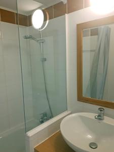 a bathroom with a sink and a shower with a mirror at Apartment Near The Slopes La Plagne in La Plagne