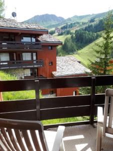 a balcony with chairs and a view of a house at Apartment Near The Slopes La Plagne in La Plagne