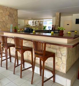 a kitchen with a large counter with four chairs at Montana Eco Resort in Oranjestad