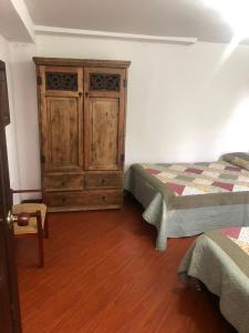 1 dormitorio con 1 cama y armario de madera en HACIENDA MONCORA CABAÑA LAGO p 1, en El Rosal