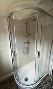 a shower with a glass enclosure in a bathroom at Viking Cottage in Arrochar