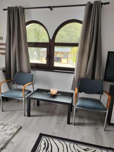 sala de estar con 2 sillas y mesa en ZEN SPOT Satic, en Sătic