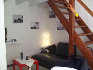 a living room with a couch and a wooden staircase at Appartements Les remparts d'Alienor in Poitiers