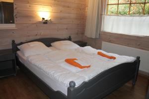 a bedroom with a bed with orange towels on it at Chalet Nieuw Beusink in Winterswijk