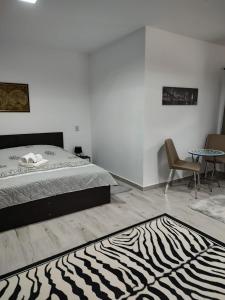 1 dormitorio con cama y alfombra de cebra en ZEN SPOT Satic, en Sătic