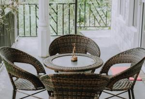 a patio with three chairs and a table with a candle at Berghaus Bungalow in Ella