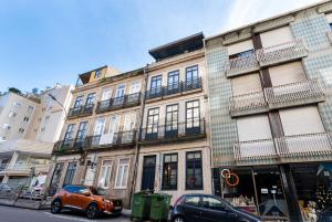 un coche naranja estacionado frente a un edificio en Boavista Rilofe Stay T1 Smart Duplex - by Guest SPA, en Oporto