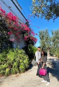 a man and a woman with a pink suitcase at Villa del 1700 immersa nel verde, Poggio al Sole Vieste in Vieste +33 photos