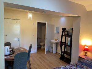 a room with a dining room table and a bathroom at Beautiful 1-Bed studio Lickey Hills Birmingham in Birmingham