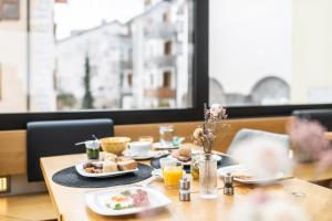 uma mesa com pratos de comida e bebidas em La Tgoma - Hotel & Restaurant em Lenz