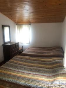 Un dormitorio con una cama grande y una ventana en Hacienda Moncora cabaña lago p2, en El Rosal