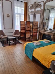 a bedroom with a bed and some dressers at Les Appartements Fénelon in Le Cateau