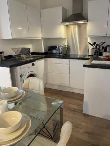 a kitchen with white cabinets and a glass table at Modern Studio in popular South Kensington location in London