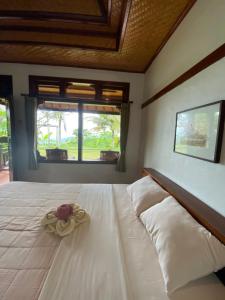 a bedroom with a white bed with a flower on it at Geriasemalung in Tirtagangga