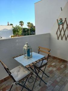 einen Tisch und Stühle mit einer Laterne auf dem Balkon in der Unterkunft Dúplex con espectaculares vistas del Rompido in El Rompido