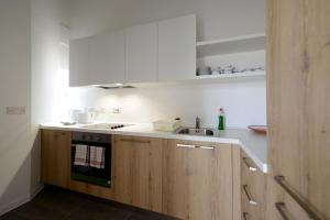 a kitchen with wooden cabinets and a sink at Harbour Gem Sea View 6 by VallettaStay in Valletta