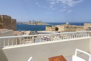 a balcony with white chairs and a view of the ocean at Harbour Gem Sea View 6 by VallettaStay in Valletta