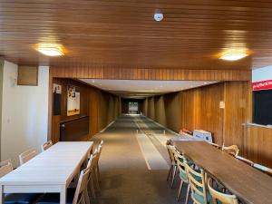 un long couloir avec des tables et des chaises dans un bâtiment dans l'établissement Lemmerhof, à Eslohe